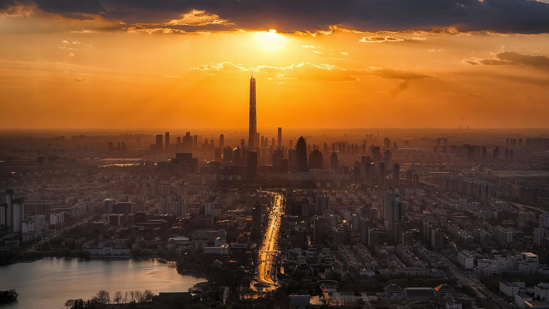 Photo d'un ciel avec un coucher de soleil orang&eacute; au dessus d'une ville avec des grattes-ciel